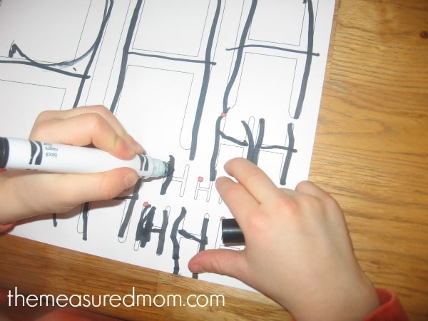 child writing on letter H worksheet