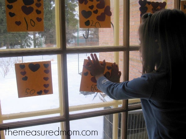 child placing paper on window