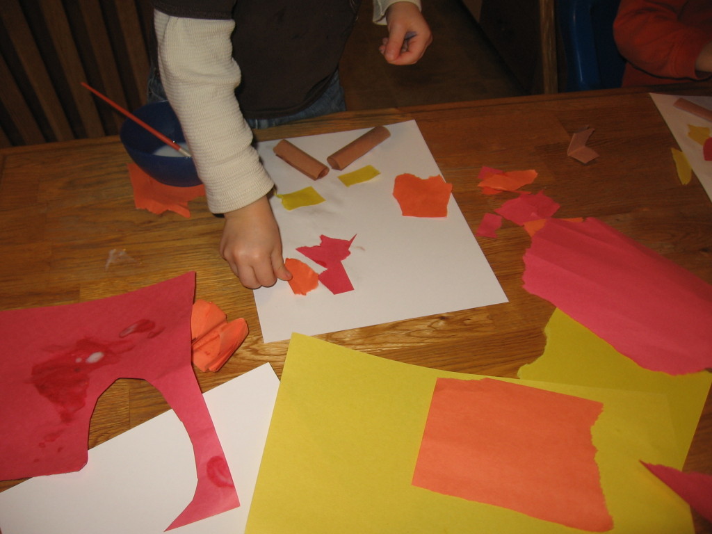 child placing colored paper on paper