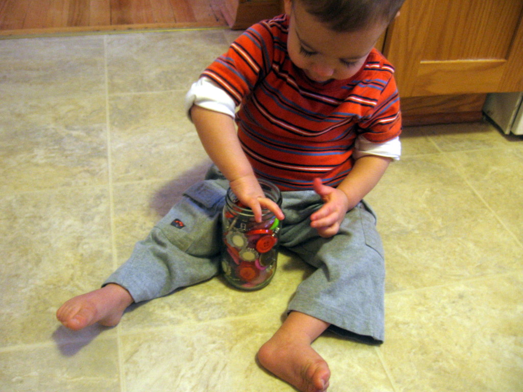 child trying to take button out of jar