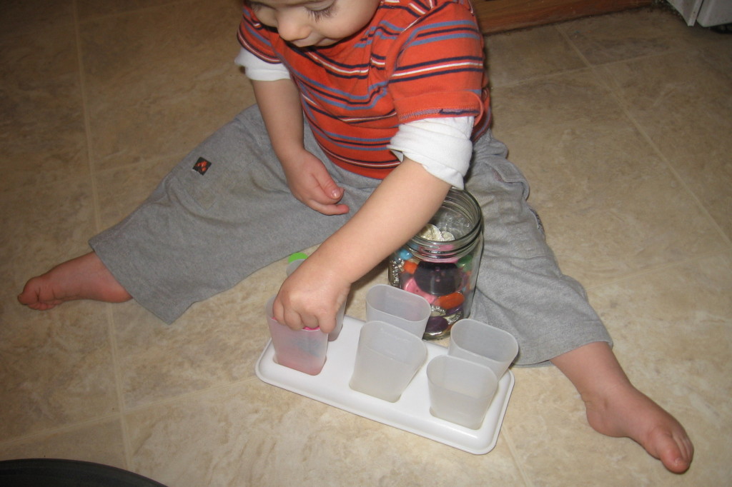 child placing button into popsicle mold