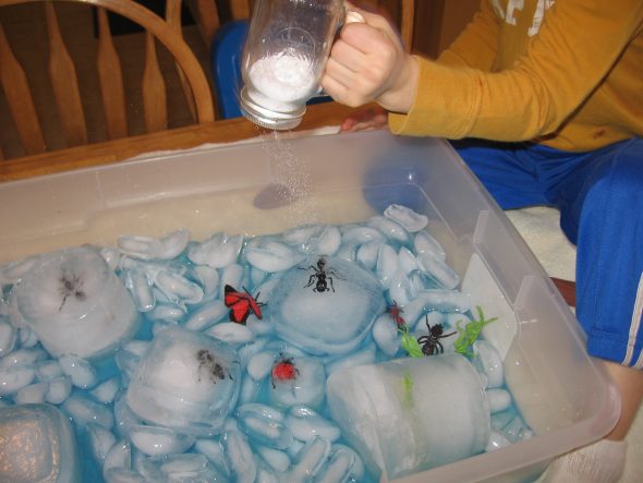 child shaking salt into bin