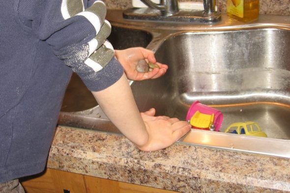 child washing rocks