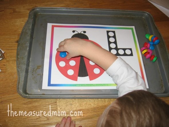 child placing magnet on letter L worksheet