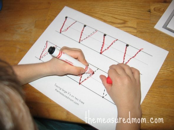 child writing on V worksheet