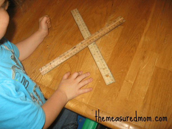 child with letter X made with rulers