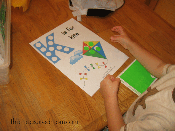 child placing dot stickers on K is for kite worksheet