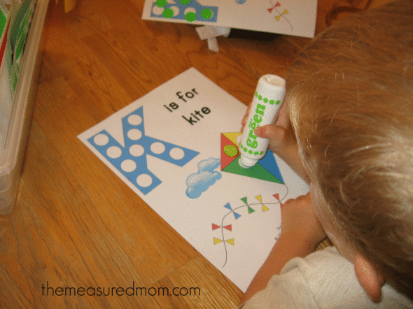 child stamping Do-A-Dot marker on K is for kite worksheet