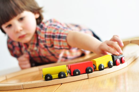 Little boy playing with a toy train